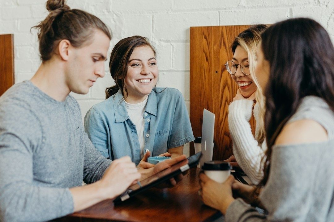 Fyra studenter samlas kring ett bord med dator och anteckningar